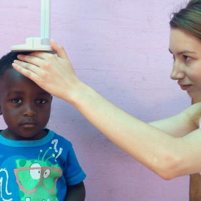 Un niño local es pesado y medido durante nuestra pasantía de Nutrición en Sudáfrica. Pasante de Nutrición en Sudáfrica midiendo a un niño.
